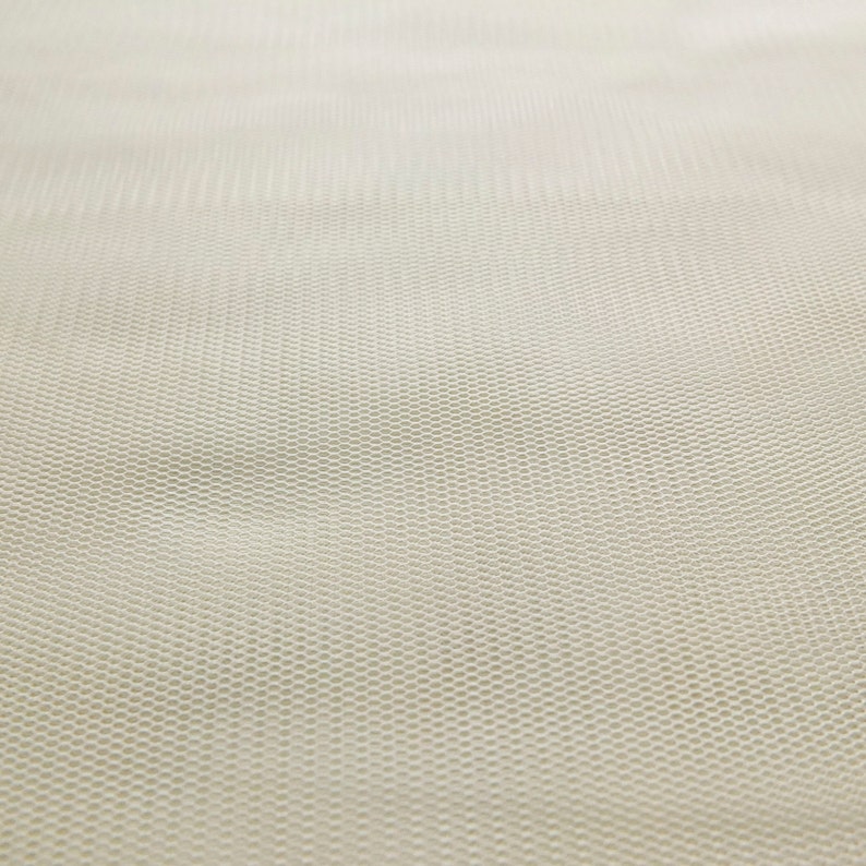 Puede incluir: Primer plano de una tela de tul blanca con un patr&oacute;n de malla fina.