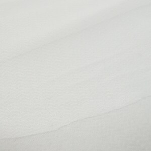 May include: A close-up of a white, smooth, textured surface.