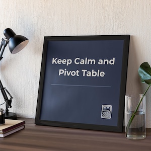 Puede incluir: Un marco cuadrado negro que contiene una impresión azul oscuro con el texto blanco Keep Calm and Pivot Table, una línea horizontal fina y un pequeño icono blanco de una calculadora con cara. El marco está colocado sobre una superficie oscura.