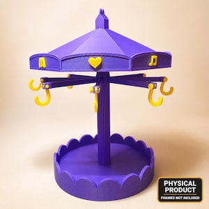 Pode incluir: Um suporte de exibição estilo carrossel na cor roxa com um pilar central, uma base festonada e um telhado decorado com ícones amarelos, incluindo um coração e uma nota musical. A estrutura inclui vários ganchos amarelos no topo.