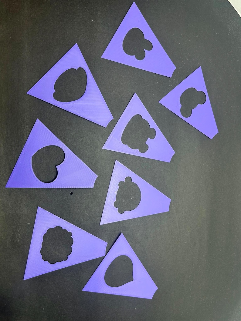 Pode incluir: Uma cole&ccedil;&atilde;o de oito est&ecirc;nceis de pl&aacute;stico roxo, cada um em forma de tri&acirc;ngulo com um design recortado exclusivo no centro. Os recortes apresentam v&aacute;rias formas, incluindo contornos arredondados, formas de nuvens e silhuetas org&acirc;nicas irregulares.