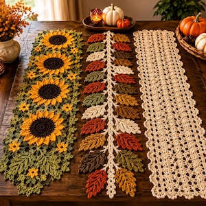 Puede incluir: Tres caminos de mesa rectangulares de ganchillo dispuestos uno al lado del otro. El camino de la izquierda presenta girasoles amarillos con centros marrón oscuro y hojas verdes. El central tiene una enredadera con hojas otoñales de colores.