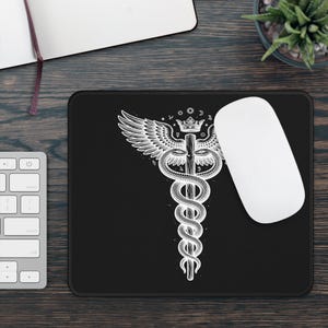 Può includere: Un tappetino per mouse rettangolare nero con un'illustrazione a linee bianche di un simbolo del caduceo. Il design include un bastone centrale intrecciato da due serpenti, sormontato da un paio di ali e una corona, circondato da piccole icone celesti.