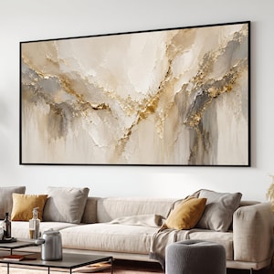 Pode incluir: Uma grande peça de arte de parede retangular com uma paisagem abstrata com camadas espessas e texturizadas de tinta creme, bege e cinza. A composição é acentuada com detalhes em folha de ouro que criam um efeito cintilante em relevo.