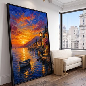 Könnte beinhalten: Ein großes, rechteckiges gerahmtes Wandbild mit einem Ölgemälde eines Küstensonnenuntergangs. Die Szene zeigt ein kleines Boot auf dunkelblauem Wasser, das einen leuchtend orangefarbenen und gelben Himmel reflektiert, mit einem Weg und einer Lampe.