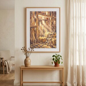 Könnte beinhalten: Ein gerahmtes Ölgemälde, das das Innere einer rustikalen Holzscheune darstellt. Die Szene zeigt goldene Heuballen, eine Holzleiter, eine Metalllaterne und Heugabeln. Sonnenlicht fällt durch eine offene Tür und beleuchtet die strukturierten Holzwände und den Boden mit warmem, hellem Licht und tiefen Schatten.