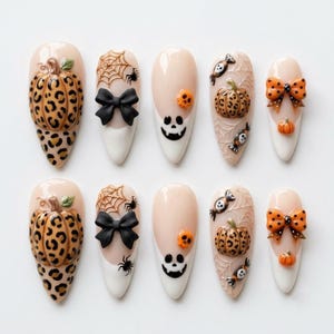 Puede incluir: Un juego de diez uñas postizas con diseños de Halloween. Las uñas incluyen elementos en 3D como calabazas con estampado de leopardo, lazos negros, telarañas con arañas, caras de fantasmas, calaveras naranjas y lazos de lunares sobre base nude.