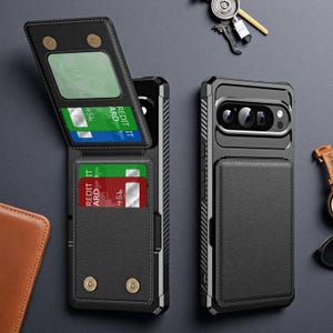 Könnte beinhalten: Eine schwarze Schutzhülle für Mobiltelefone mit aufklappbarem Portemonnaie-Teil. Das Portemonnaie verfügt über ein transparentes Sichtfenster und Fächer für grüne und rote Kreditkarten sowie zwei metallische Druckknöpfe.