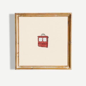 Peut inclure: Une œuvre d'art murale encadrée de forme carrée présentant une illustration centrée d'un funiculaire rouge avec deux fenêtres et le mot PITTSBURGH imprimé en lettres noires sur le côté, sur un fond blanc cassé dans un cadre en bois.