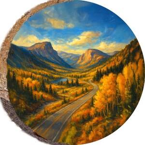 May include: A round wooden art piece featuring a landscape painting of a winding road through a valley. The artwork showcases a vibrant autumn scene with golden trees, a blue sky, and distant mountains. The painting is set within a natural wood frame.