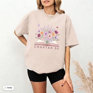 Maglietta personalizzata per il compleanno con tema "Fiori selvatici, libro aperto", ideale per lettori appassionati di libri, per un compleanno importante, con colori confortevoli.