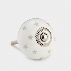 May include: White ceramic knob with a silver star pattern and a silver metal centre.
