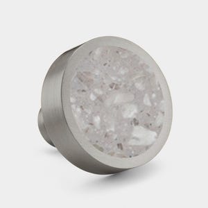 May include: A round, silver cabinet knob with a white terrazzo inlay. The knob has a smooth, polished finish.