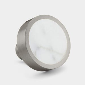 May include: A round, silver knob with a white marble inlay. The knob has a smooth, brushed finish.