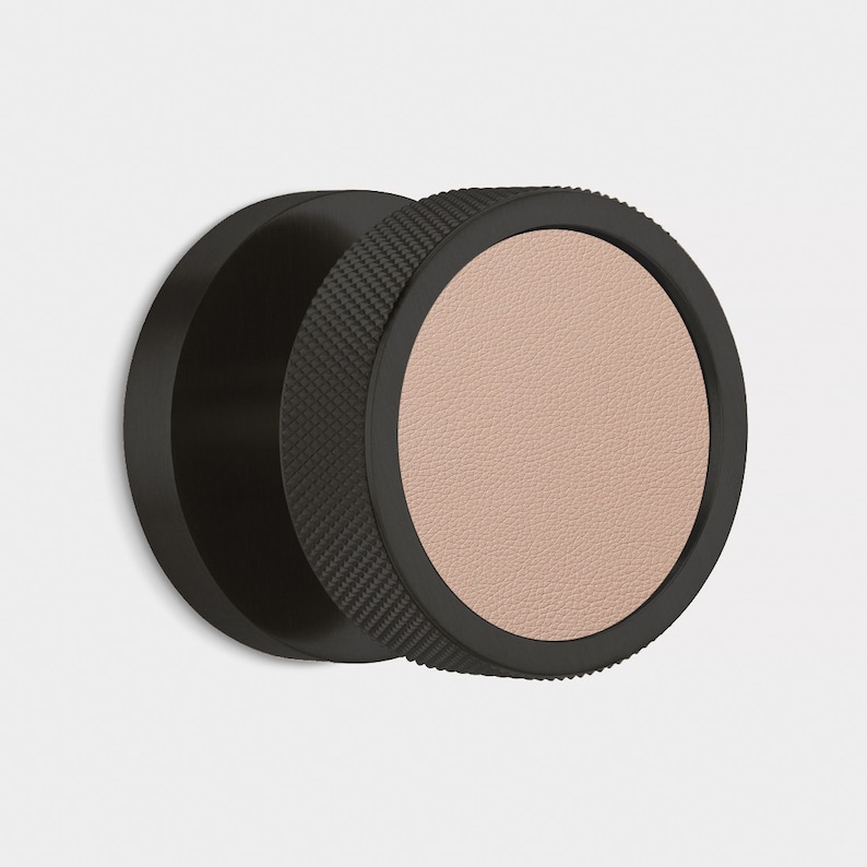 Peut inclure: Un objet circulaire noir avec un bord textur&eacute; et un centre beige clair. L'objet semble &ecirc;tre fait de m&eacute;tal et de cuir. Le design est moderne et minimaliste, ax&eacute; sur la texture et la forme.