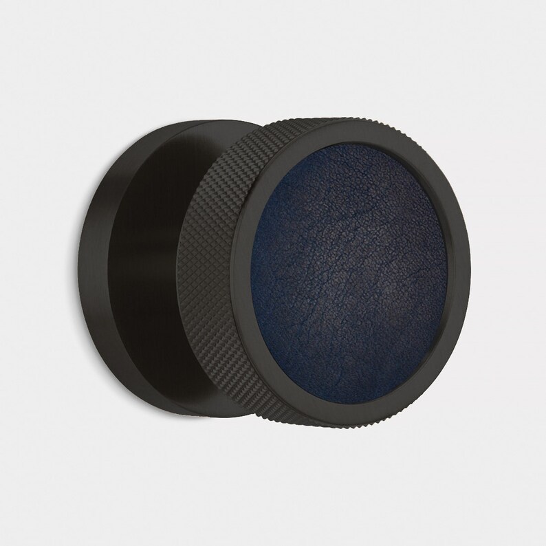 Peut inclure: Objet circulaire noir avec un anneau ext&eacute;rieur textur&eacute; et un centre en similicuir bleu fonc&eacute;. L'objet a une finition mate et semble &ecirc;tre un &eacute;l&eacute;ment d&eacute;coratif ou un accessoire.