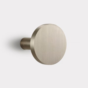 May include: A brushed nickel round curtain rod finial.