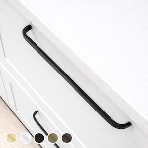 May include: A black, rectangular cabinet pull handle with rounded ends is mounted on a white cabinet. The handle has a matte black finish. The cabinet has a recessed panel design. Several colour options are shown below the cabinet.