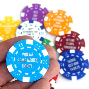 May include: A selection of poker chips in various colours, each with a different message. A blue chip in the foreground says "WIN ME SOME MONEY, HONEY!". Other chips are purple, orange, red, yellow, and blue, with white text. Ideal for a game or event.