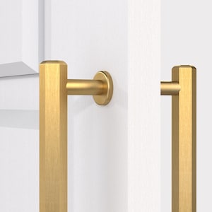 May include: Two gold-toned cabinet door pulls with a rectangular shape and a brushed finish. The pulls are mounted on a white door.
