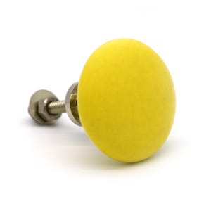 May include: A bright yellow, oval-shaped cabinet knob with a silver metal screw and backing. The knob is a solid, cheerful color, perfect for adding a pop of color to furniture. The hardware is designed for easy installation.