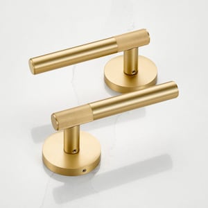 May include: Two gold-coloured door handles. Each handle features a cylindrical bar with a textured grip and a circular base. The handles are made of metal and are designed for a modern aesthetic. The handles are shown against a white background.