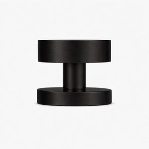May include: A matte black door handle with a cylindrical post connecting two circular discs. The handle has a minimalist design and a smooth, non-reflective surface. The door handle is made of metal.