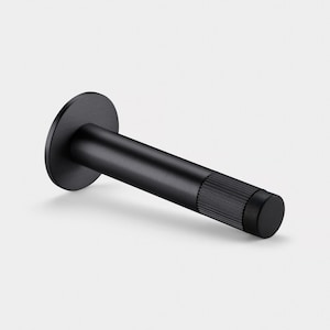 May include: A matte black bottle stopper with a circular top and a cylindrical body. The end of the stopper has a textured, ridged design. The stopper is designed to seal a bottle.