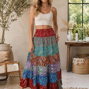 Puede incluir: Un top corto de canalé en color beige combinado con una falda larga de capas con un estampado de cachemira multicolor en tonos rojo, azul, turquesa y morado. La falda cuenta con una cintura elástica ancha y fruncida y una silueta fluida.