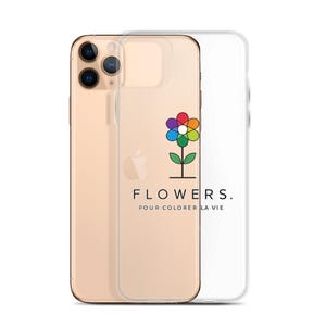 Peut inclure: Une coque de smartphone transparente ornée d'un motif de fleur multicolore aux pétales rouges, orange, jaunes, verts, bleus et violets. Sous la fleur, le texte FLOWERS. POUR COLORER LA VIE est inscrit en noir sur la surface transparente.