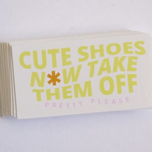 May include: A stack of white cards with the text "Cute Shoes Now Take Them Off Pretty Please" printed in yellow letters with an orange asterisk.