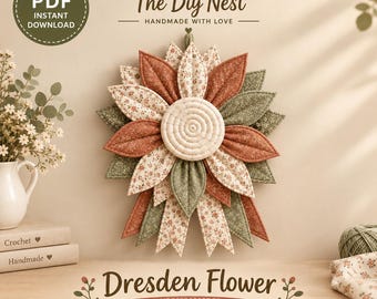 Könnte beinhalten: Ein Wandbehang aus Stoff in Blumenform mit geschichteten Blütenblättern in Rost, Salbeigrün und cremefarbenen Blumenmustern. Die Mitte ist ein kreisförmiges Steppteil. Text: The Diy Nest, Dresden Flower, Crochet Pattern.