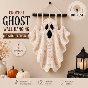 May include: A cream-colored crochet ghost wall hanging suspended from a dark wooden branch with a white rope. The ghost features two black oval eyes and a black oval mouth. Text on the image reads: CROCHET GHOST WALL HANGING DIGITAL PATTERN.