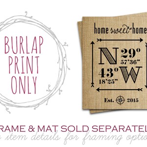May include: A burlap print with the text "home sweet home" and coordinates "N 29&deg; 57'36" 43&deg; 18'25" W" and "Est. 2015". The print is framed with a gray wreath.