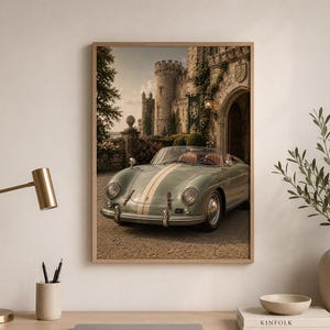 Op de afbeelding: Een ingelijste muurkunstprint met een vintage lichtgroene cabriolet sportwagen met een witte racestreep, geparkeerd op een grindpad voor een stenen kasteel met een grote boogvormige ingang en met klimop begroeide muren onder een bewolkte lucht.