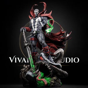 Puede incluir: Una detallada figura coleccionable de Spawn que muestra una figura musculosa con traje gris, emblema blanco en el pecho, capa roja fluida y guanteletes rojos con púas. El personaje sostiene una espada grande sobre una criatura con detalles verdes.