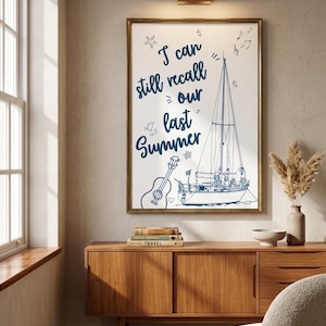 May include: A rectangular wall art print in a gold frame featuring the dark blue text I can still recall our last summer, accompanied by line art illustrations of a sailboat, an acoustic guitar, musical notes, and a small starfish.