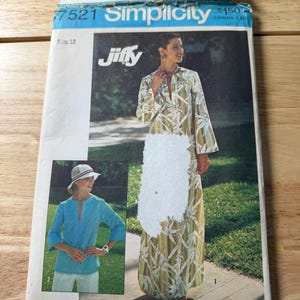 May include: A Simplicity Jiffy sewing pattern envelope, number 7521, size 12. The front displays a long-sleeved, floor-length dress with a white bamboo-style print on a light green background, and a separate image of a light blue tunic top.