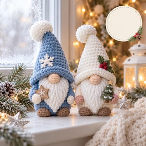 Puede incluir: Dos figuras de gnomos de ganchillo con gorros puntiagudos. El gnomo de la izquierda lleva un gorro azul con un copo de nieve blanco y sostiene una estrella. El de la derecha lleva un gorro blanco con hojas verdes y bayas rojas y un árbol.