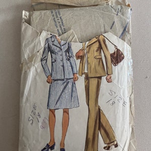 May include: Vintage sewing pattern envelope with illustrations of two outfits. The first outfit is a striped skirt and jacket. The second outfit is a brown pantsuit. The pattern is size 18.
