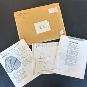May include: A set of three sewing patterns for a double tote bag, a man's op-art apron, and a pattern for a head. The patterns are printed on white paper and have black ink. The patterns are from Good Housekeeping.