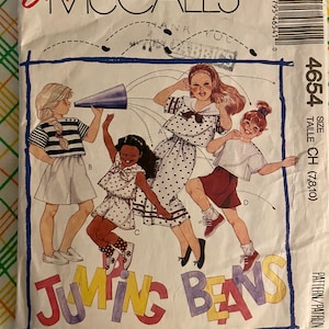 Peut inclure: Un patron de couture pour vêtements d'enfants, mettant en scène quatre filles dans différentes tenues. Le patron est intitulé "Jumping Beans" et comprend des instructions pour les tailles 7, 8 et 10. Le patron est de McCall's et porte le numéro 4654.