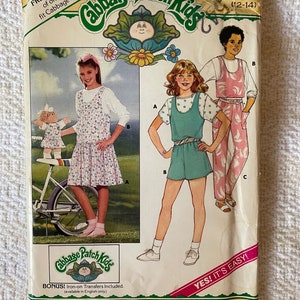 May include: A vintage sewing pattern for Cabbage Patch Kids clothing. The pattern includes three different styles of dresses for girls, sizes 12-14. The pattern is from Butterick and includes iron-on transfers.