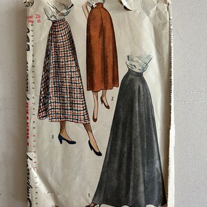 May include: Vintage Simplicity sewing pattern for a skirt. The pattern shows three different styles of skirts: a plaid skirt, a brown skirt, and a black skirt. The pattern is printed on a white background with black text. The text on the pattern includes the words "Simplicity", "Is America's Fashion", and "Copyright by".
