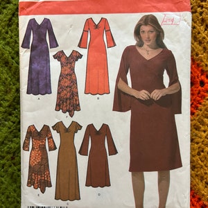 May include: Simplicity sewing pattern featuring various dress designs. The pattern includes options for dresses with long sleeves, short sleeves, and different necklines. The size range is KK 8, 10, 12, 14, and EUR 34-40, FR 36-42.