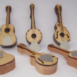 May include: Five miniature wooden musical instruments, including a banjo, a mandolin, and three acoustic guitars. Each instrument has a pick attached to it.