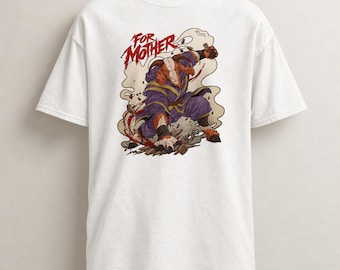 Può includere: Una t-shirt bianca a maniche corte con un'illustrazione grafica di un guerriero capra antropomorfo in una veste viola. La capra è in una posa di combattimento dinamica con il testo FOR MOTHER in rosso sopra, circondata da fumo beige vorticoso.
