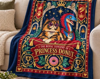 May include: A dark blue fleece blanket featuring a graphic illustration of a calico cat wearing a crown and sunglasses next to a blue and red raptor. The text reads The Royal Tapestry of Princess Donut, with banners, trophies, and a pink donut.