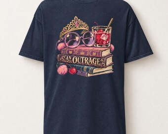 Può includere: Una t-shirt a maniche corte blu navy con una stampa grafica raffigurante una pila di tre libri, un diadema dorato, occhiali tondi, un cocktail con una ciliegia e pon-pon rosa. Il dorso del libro centrale riporta la scritta AN OUTRAGE in oro.