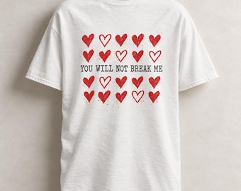Può includere: Una t-shirt bianca a maniche corte con una stampa grafica di venti cuori rossi disposti su quattro file. Il testo "YOU WILL NOT BREAK ME" è stampato in lettere maiuscole grigio scuro al centro, separando la seconda e la terza fila.